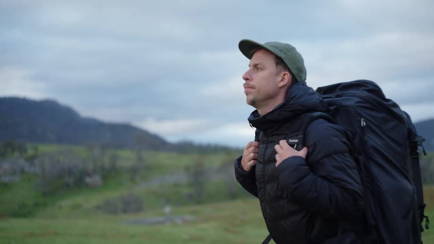A man is hiking on a cloudy day