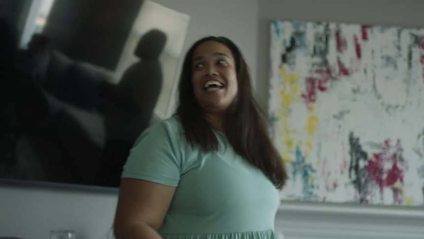 A teenager and her mom do a choreographed dance in their living room