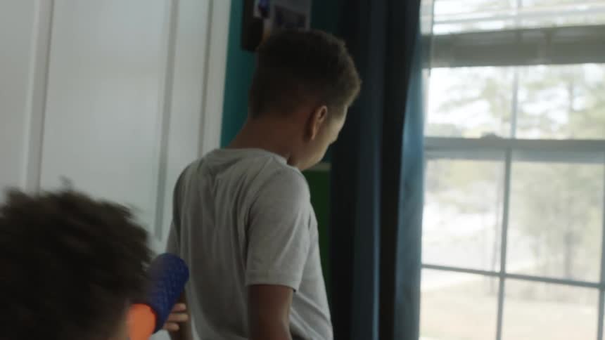 Brothers playing leisurely with toys in a room at home