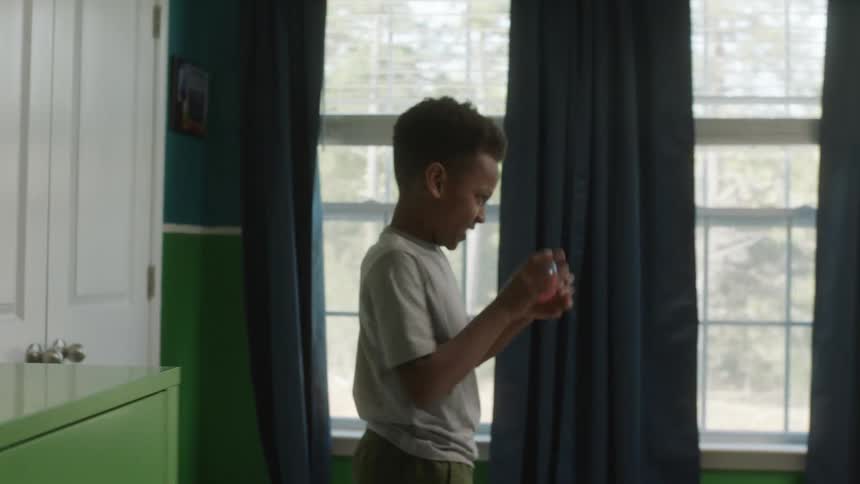 Two young brothers laughing and playing with toys in a bedroom