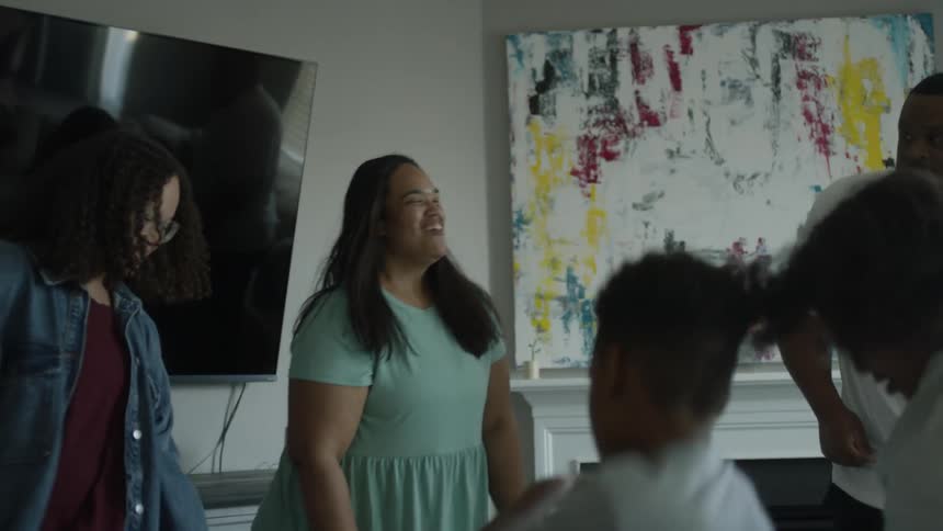 Family and friends dance in living room