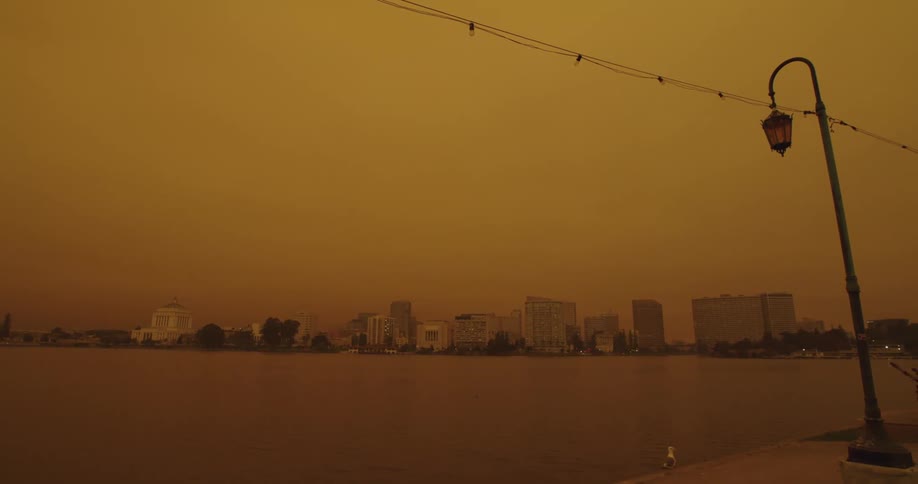 Yellow tinted footage of the skyline of a city in front of the ocean