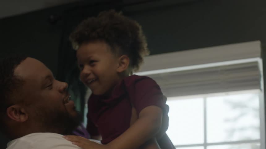 Father picks son up to allow him to participate in a video call