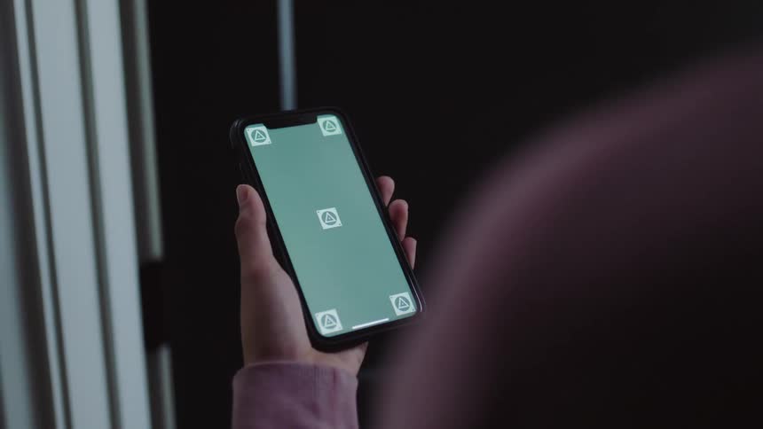 Woman raises hand to view mobile phone