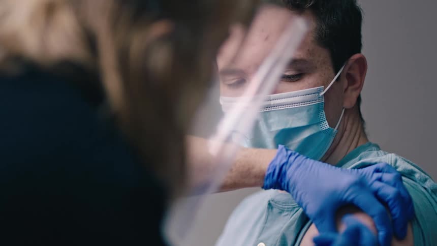 Nurse gives injection to young man