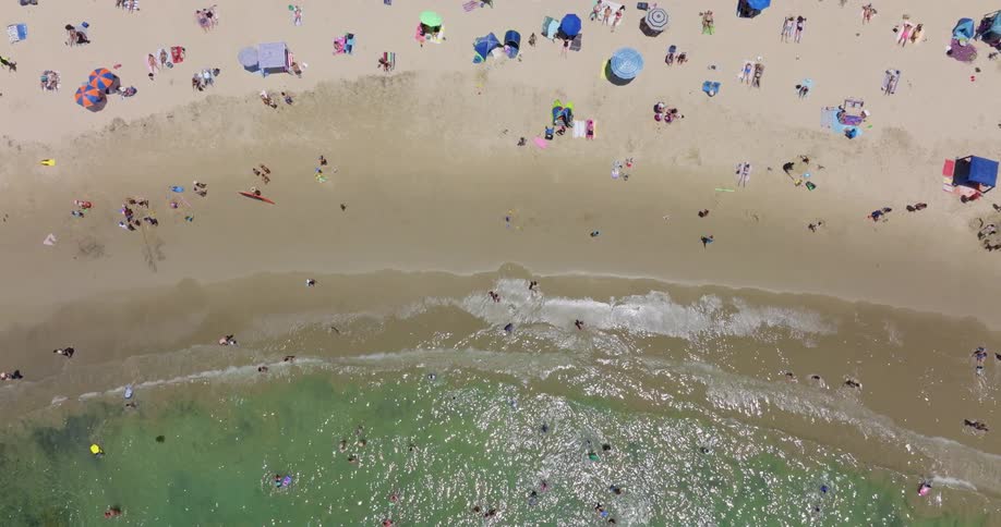 A public beach filled with people on a sunny day