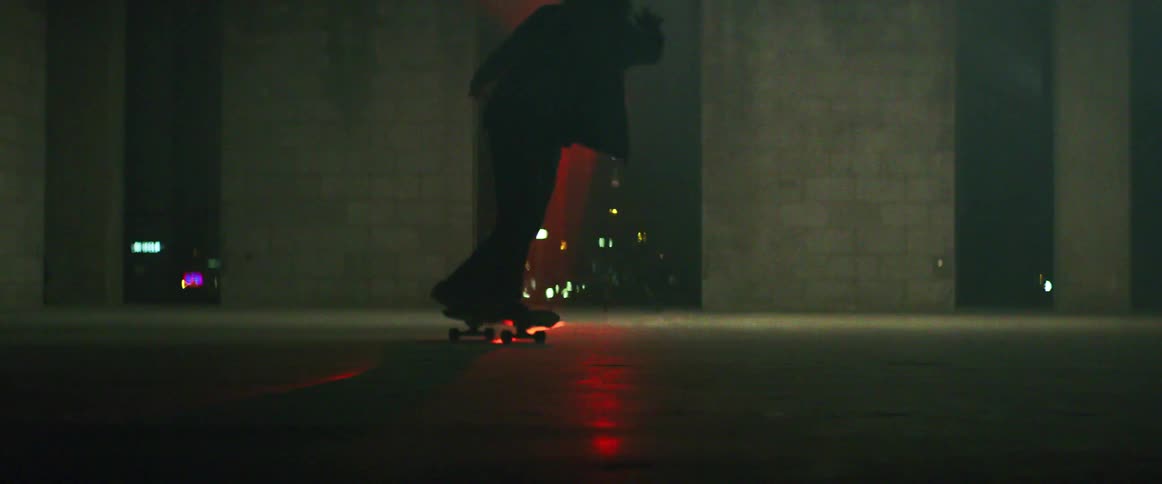 A man is riding a skateboard inside a building in the city