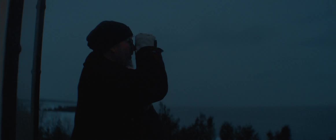 Man and woman stand on platform using binoculars while viewing landscape