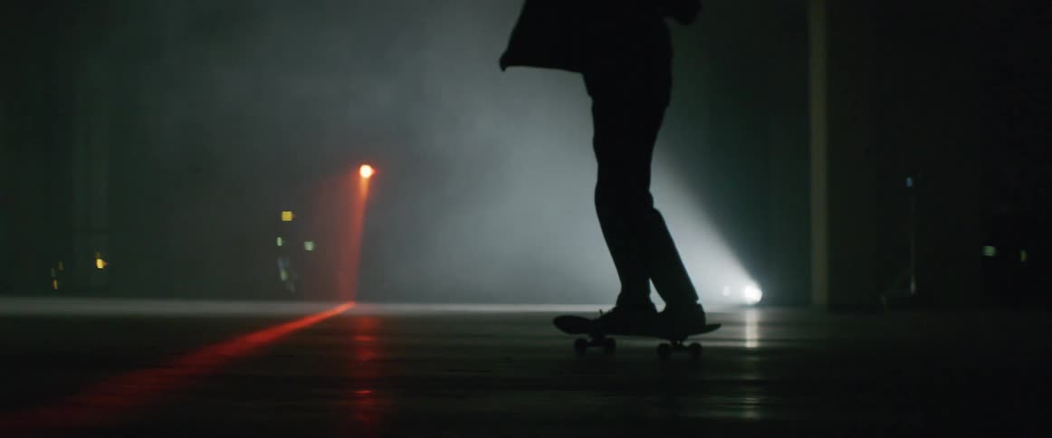 A person skating around inside an empty and dark room
