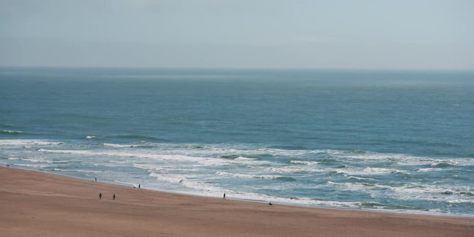 People walk on the beach in the distance