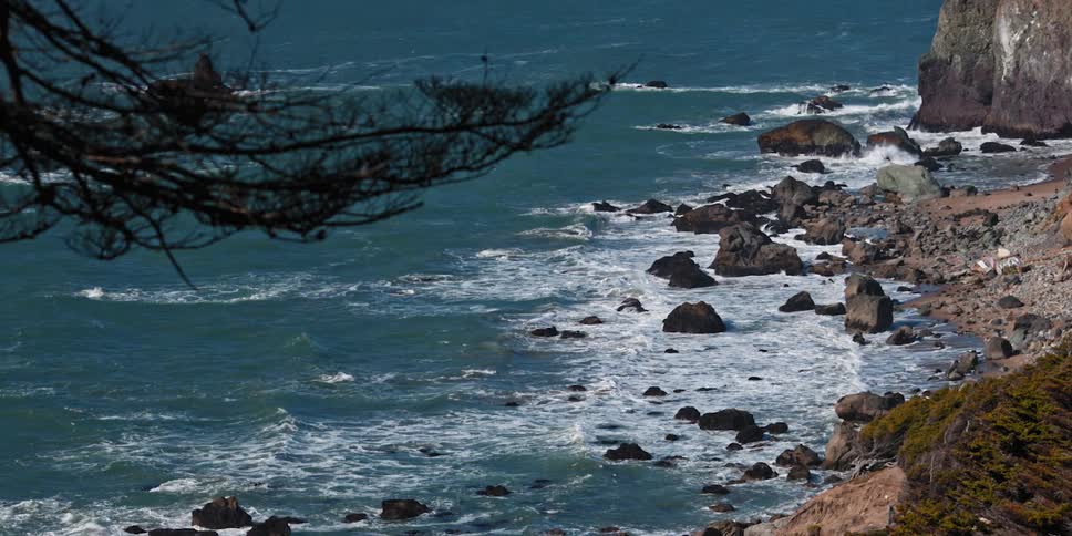 The waves crash against the rocks on the island