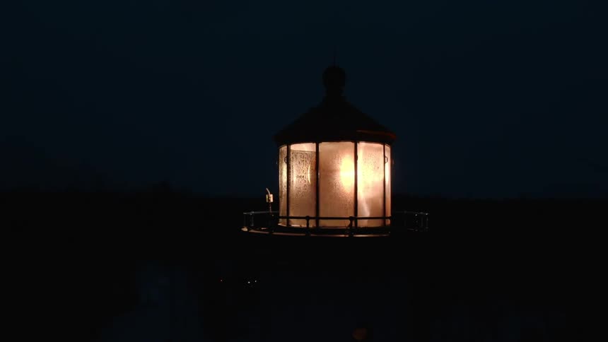 The light on a beacon is flashing brightly in the darkness