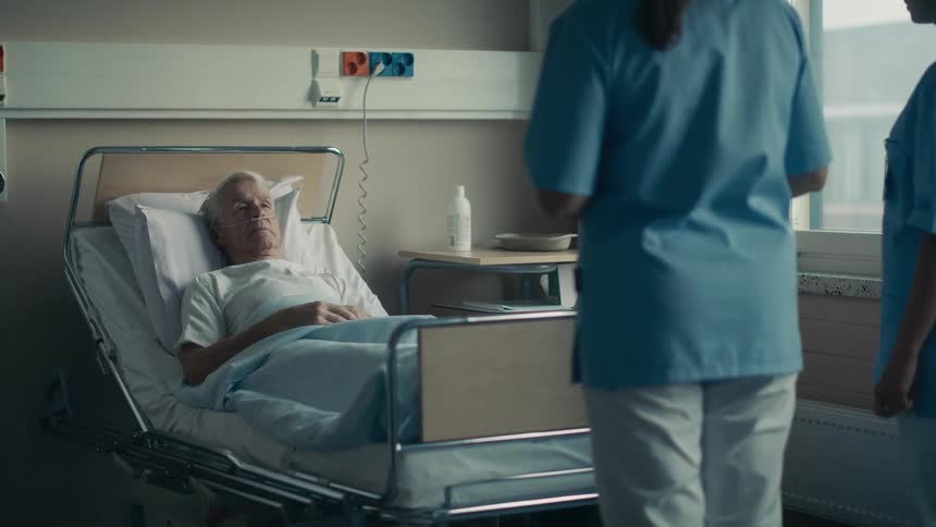 Elderly male patient and his wife are joined by a doctor and nurse