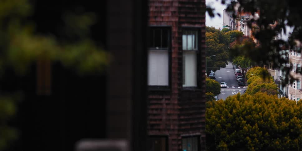 Car driving down a street with trees in the distance on the city
