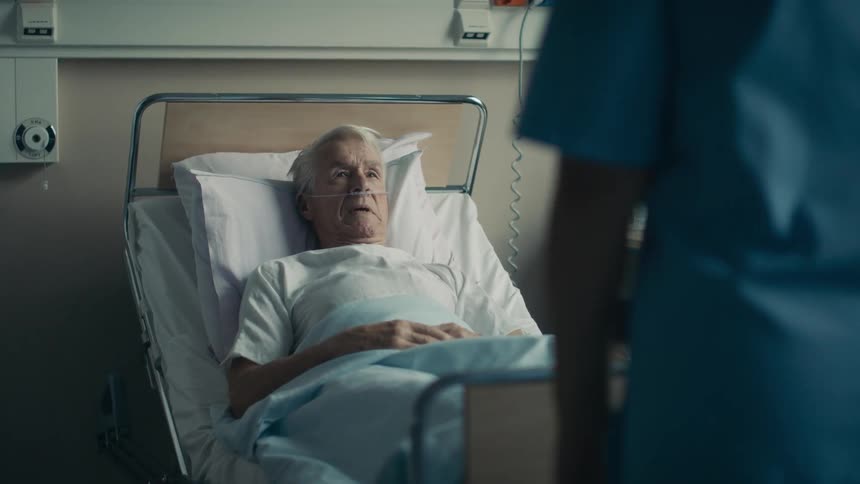 Nurses walk in to a hospital room to talk to a patient and his wife