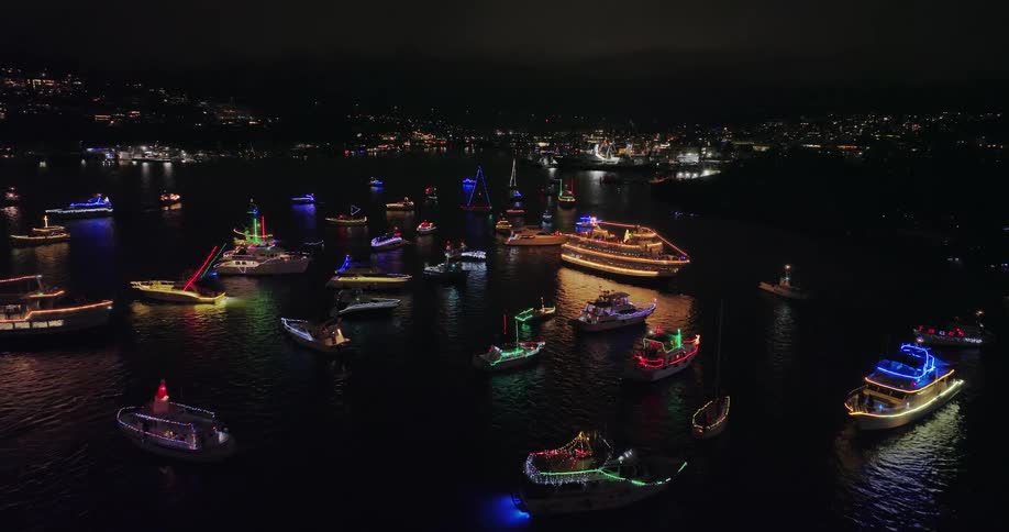People celebrate the Christmas holiday on boats and yachts lit up with colorful lights and decorations
