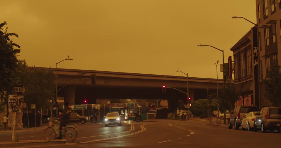 Traffic travels through intersection in a city in the evening