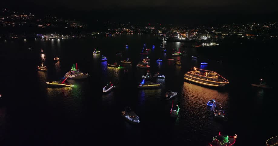A flotilla of yatchs and boats gather after a Christmas ship parade to sing carols to onlookers on shore
