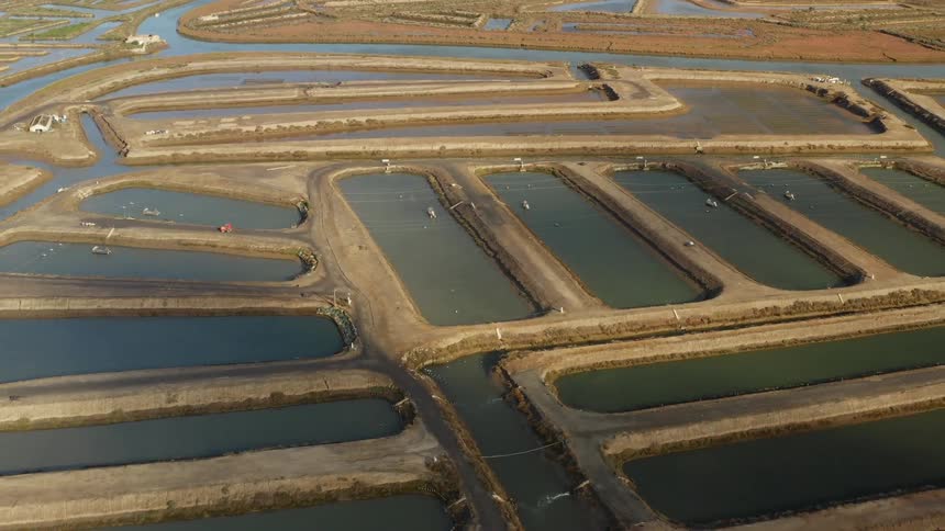River waterway flows past series of man made ponds