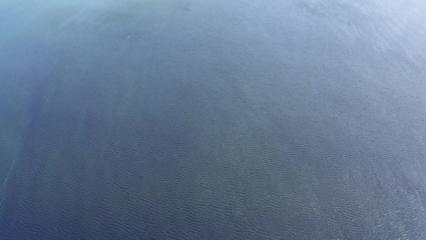 Aerial view of light clouds over the wide expance of he ocean