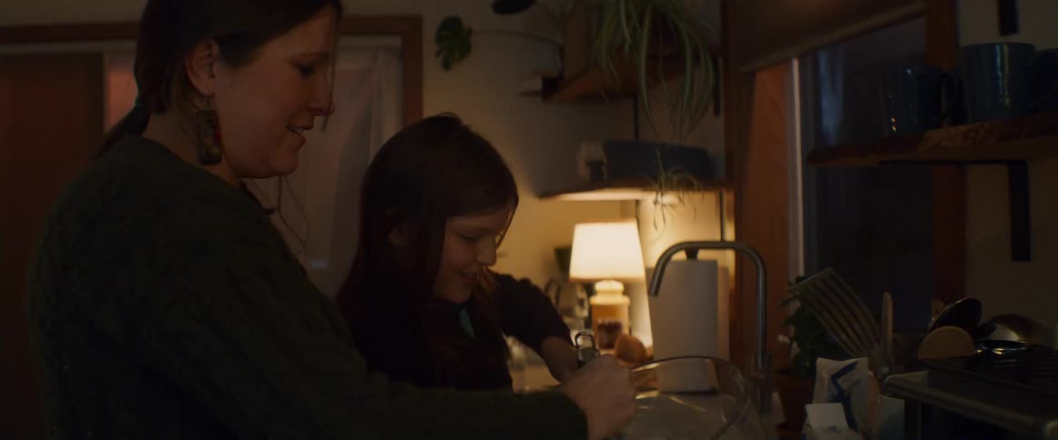 A mother and daughter talk as they cook in the kitchen
