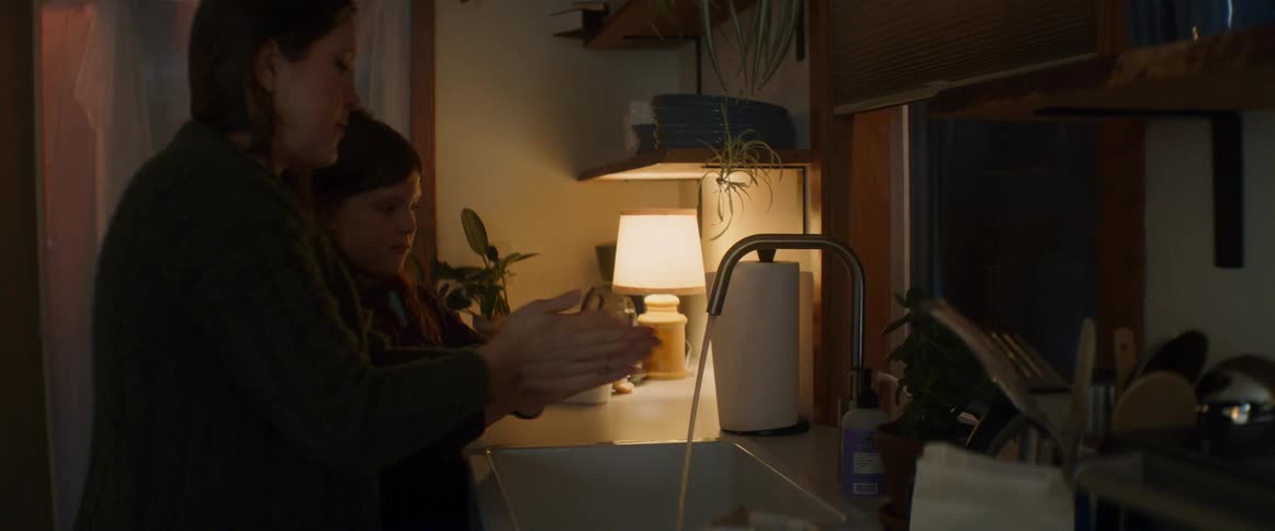 A woman and child wash their hands in the sink
