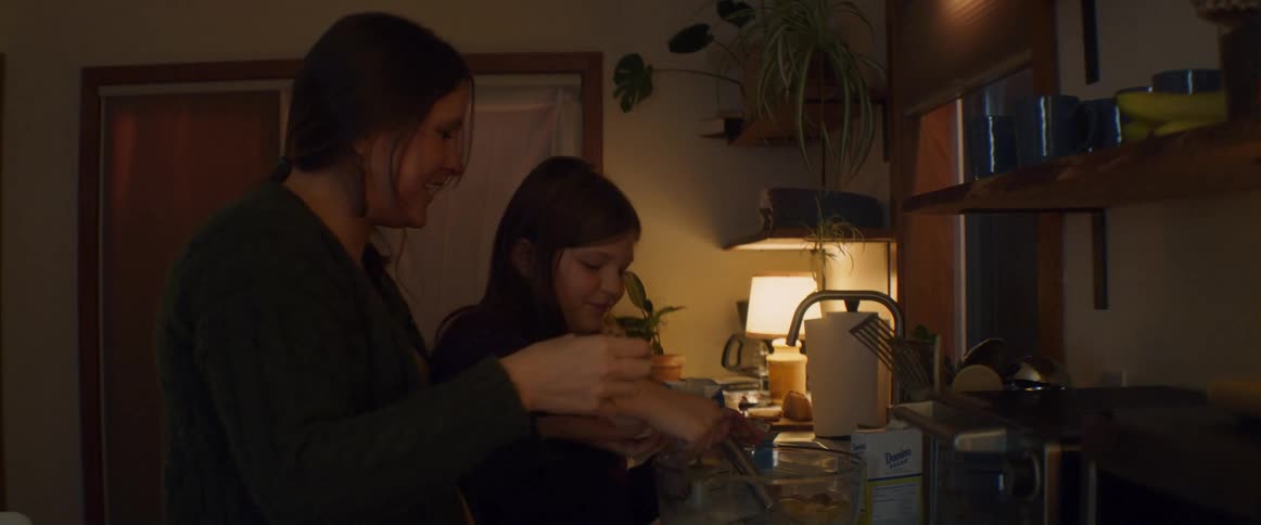 Mother and daughter cooking together and having fun at the kitchen