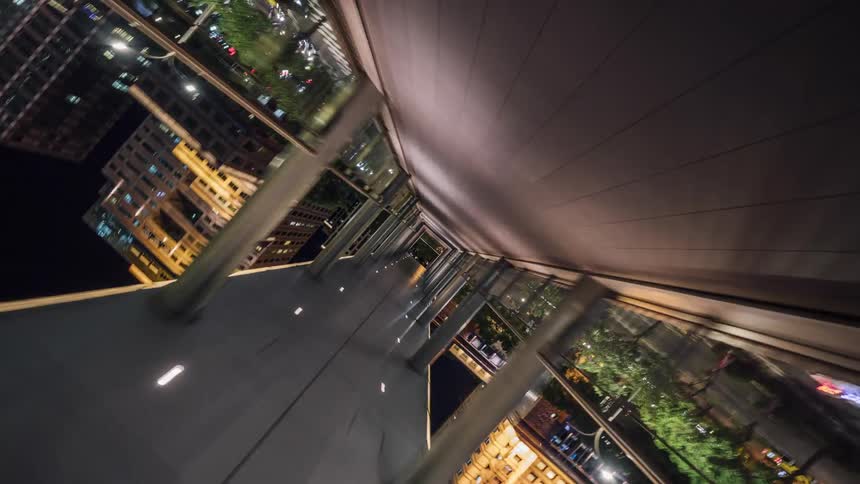 Moving down a highrise hallway open to the city skyline as it twists and turns