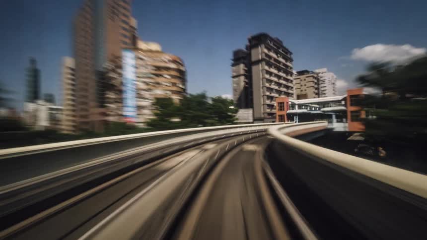 A train speeds through downtown before stopping at a train platform