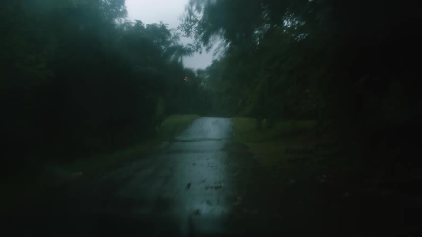 Vehicle driving on a wet rural road on a rainy day