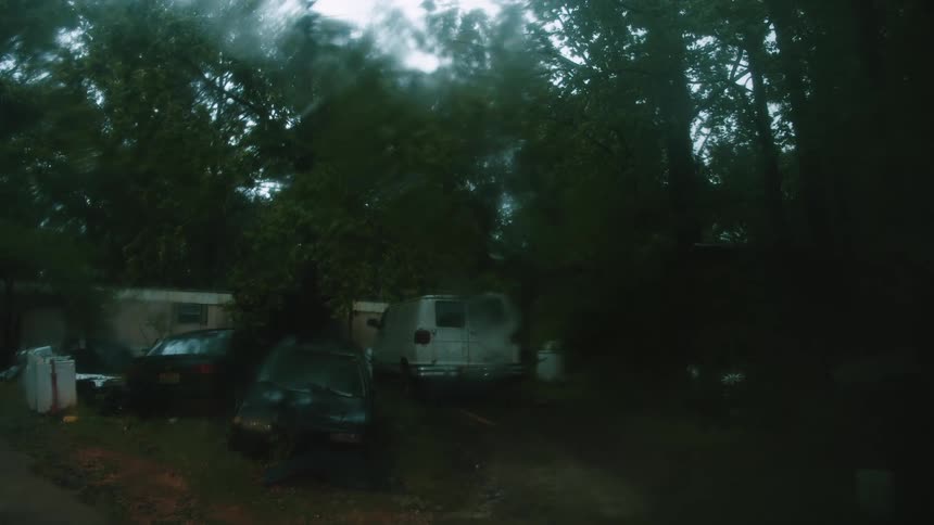 The yard is full of vehicles on a rainy day