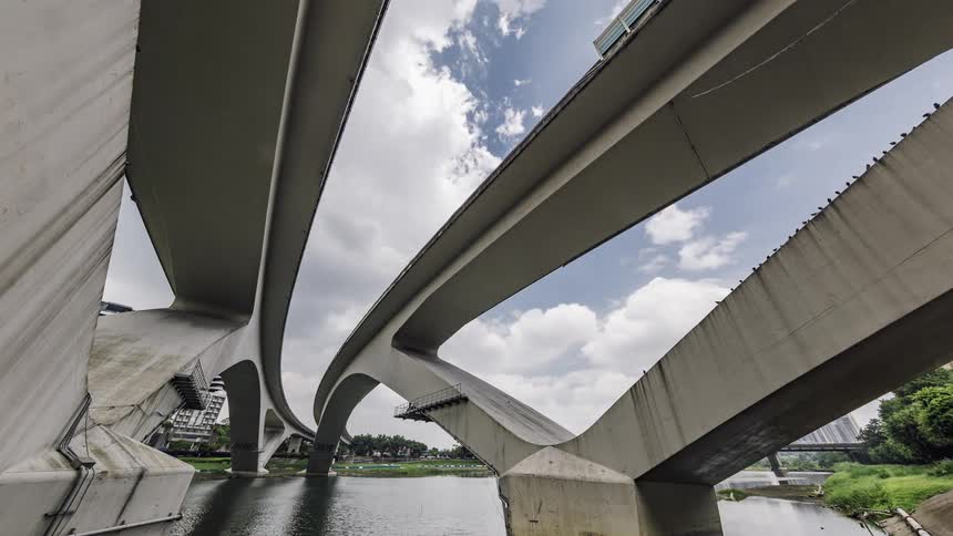 A architectural bridge passes over a river near downtown