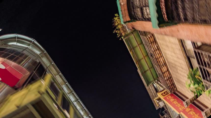People walk through a crowded night market downtown in an asian city