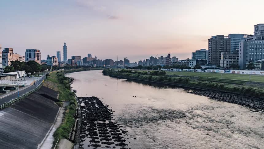 A river flowing through a city with skyscrapers at sunrise