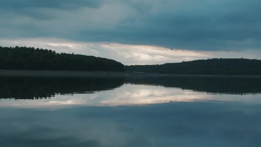 The skys reflection shows on the rippling surface of the body of water