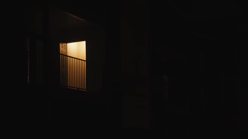 A building is displayed at night with a light on