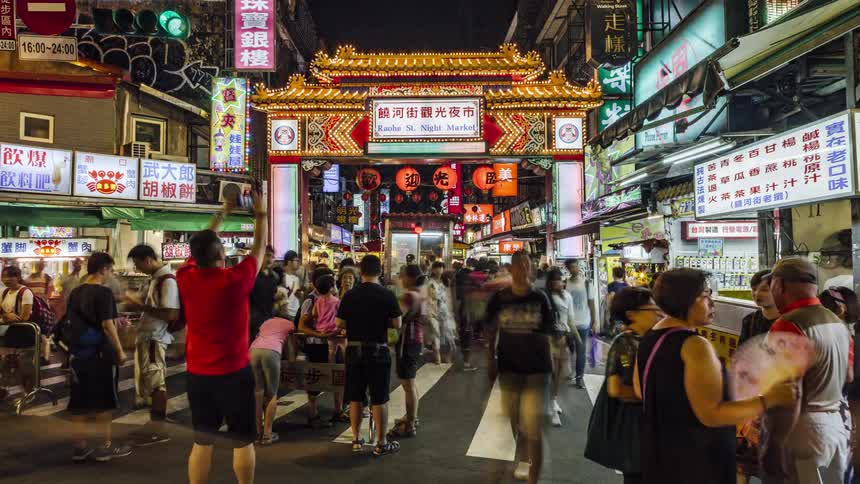 Timelapse footage of pedestrians walking and shopping on a busy chinese street at night