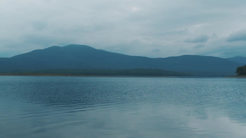 Ripples in a lake with hills on the other side of the lake