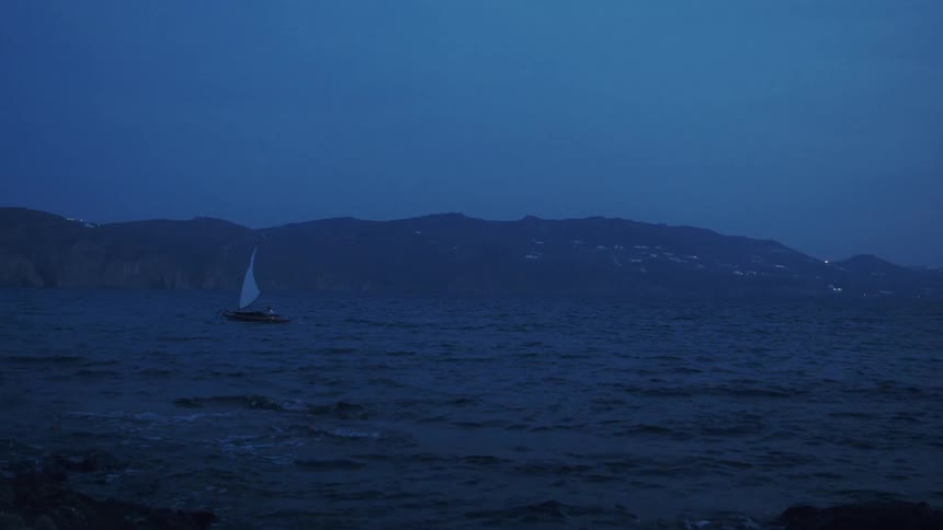 A boat is moving on a body of water at night