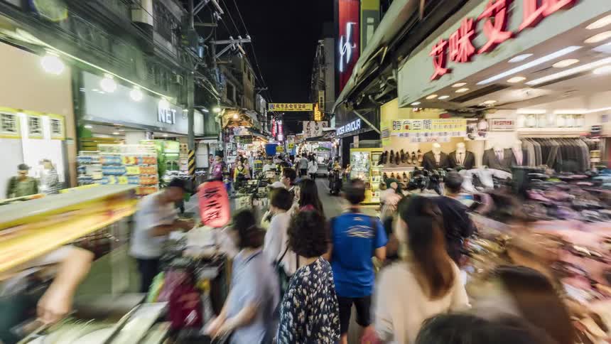 Time lapse footage of people visiting a street market in china at night