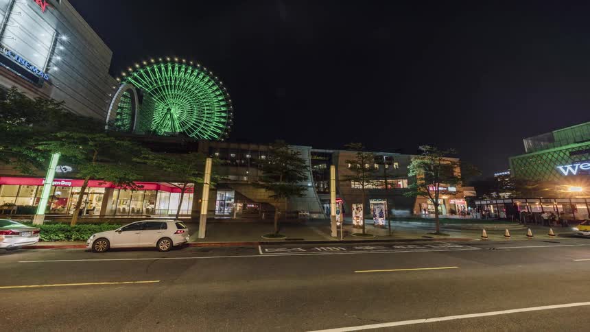 Cars are driving through a city at night
