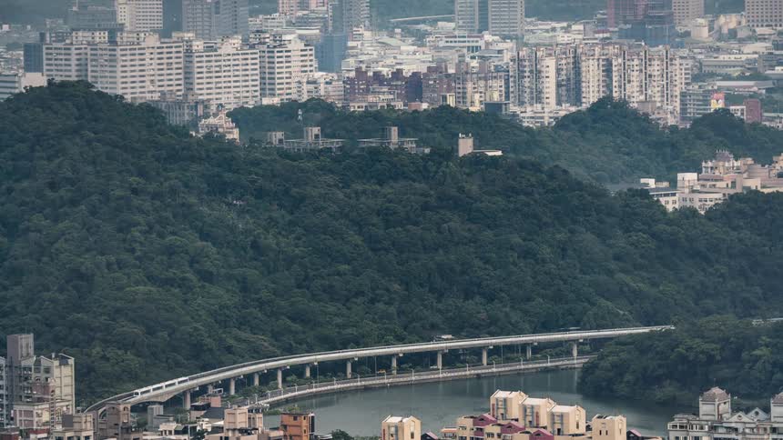 Vehicle traffic and a train pass by on a double decker bridge near downtown