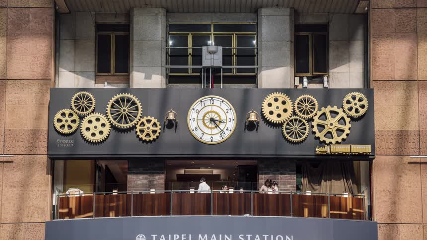 Time lapse footage of a clock with gears moving with the our over a restaurant in the taipei main station
