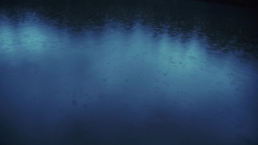Rain droplets on water during summer shower