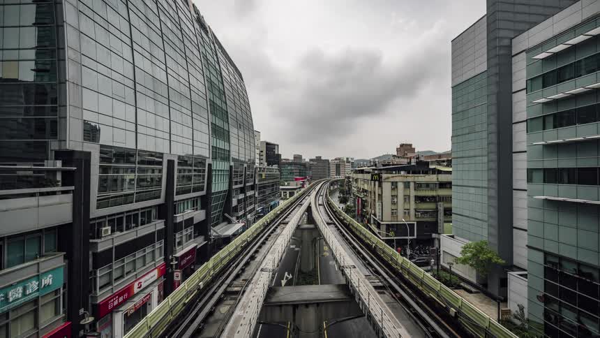 Time lapse footage of trains driving over elevated tracks through the city downtown