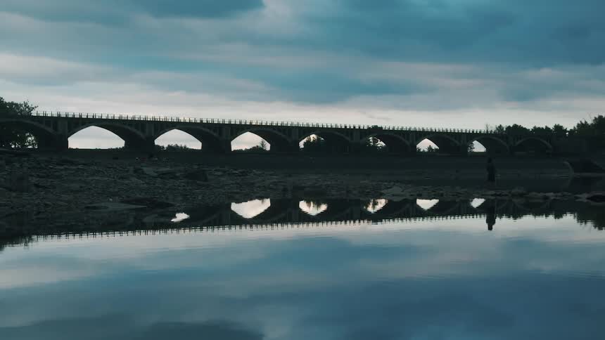 Cars are driving on a bridge above the water