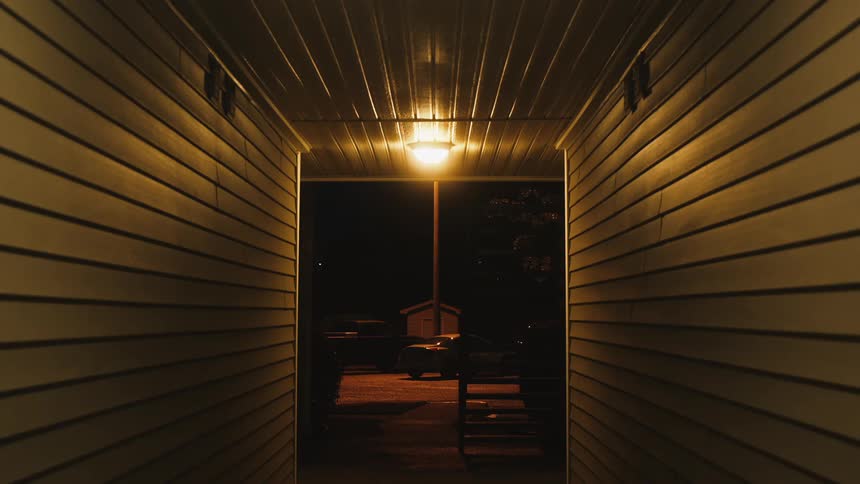 A truck parked in front of a house with siding at night