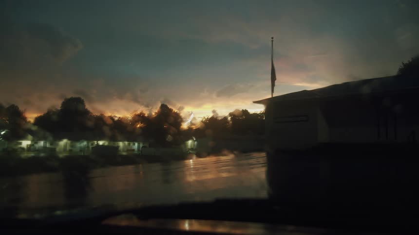 A parking lot is empty near a building at dusk