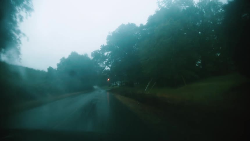 Vehicle driving on a wet rural road on a rainy day