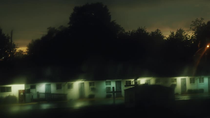 A glowing single story building on a rainy night